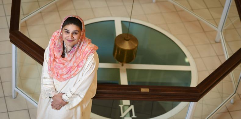 Samya Zain looking up from the pendulum in Fisher Hall